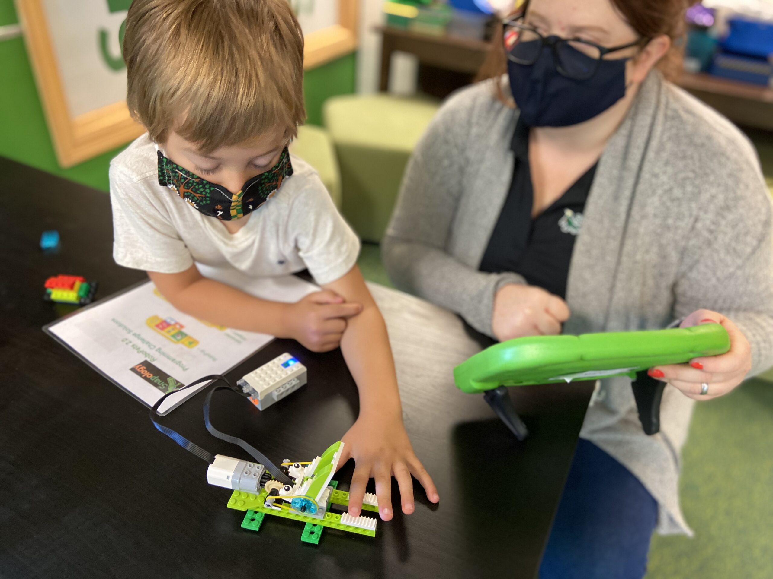 snapology instructor helping a boy with his project