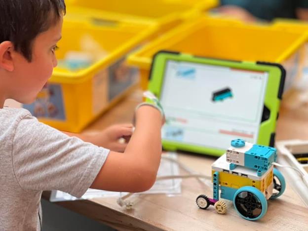 A child working with a Robotics bot learning the foundations of coding